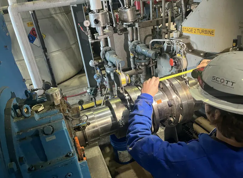 Technician measuring at a turbine coupling