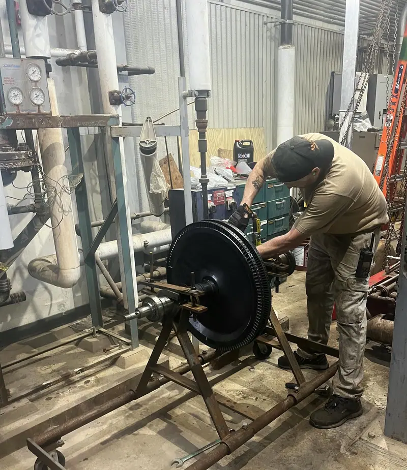 Technician working on a turbine wheel mounted on a stand
